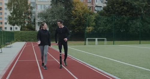 Amputee and Friend Walk on Running Track