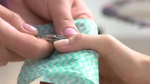 Manicurist Clips Cuticle Off Client's Fingernail