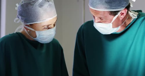 Surgeons interacting with eachother while performing operation in operation room