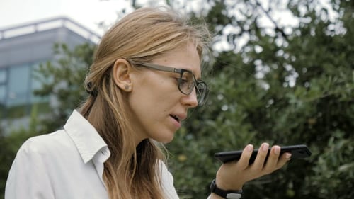 Woman Using Voice Command on Phone Outdoors