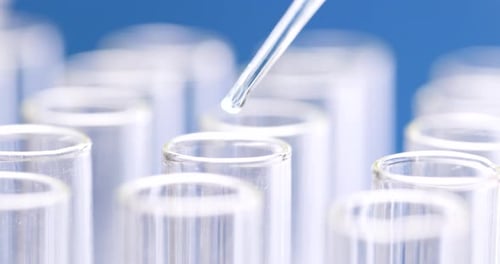 Liquid Dropping into Test Tube in Laboratory Setting