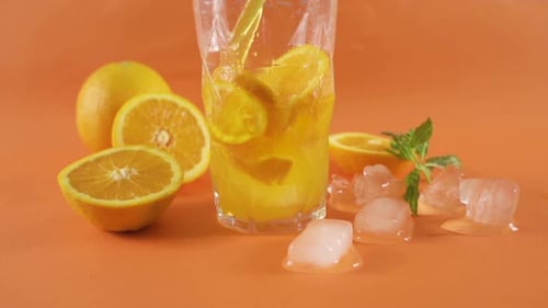 Orange Juice Being Poured in Glass with Ice