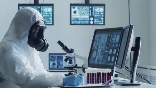 Scientist in Hazmat Suit Analyzing Samples Under Microscope