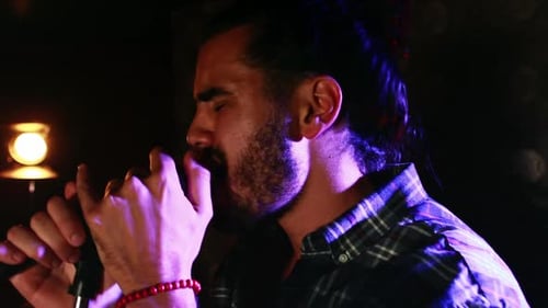 Passionate Singer Performing Under Blue Stage Lights