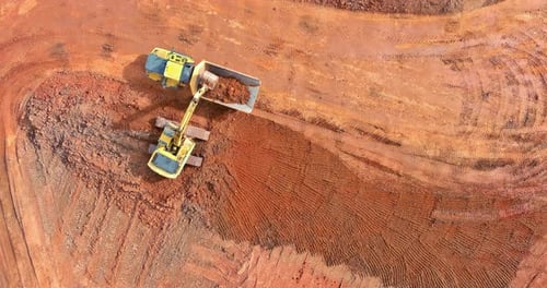 Excavator Loads Dump Truck With Dirt Aerial View