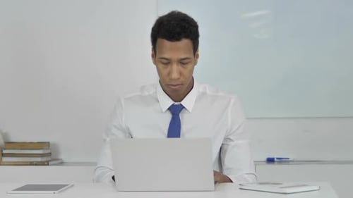 AfroAmerican Businessman Working On Laptop Frontal View