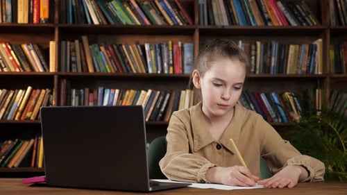 Frustrated Girl Writing at Desk Throws Paper