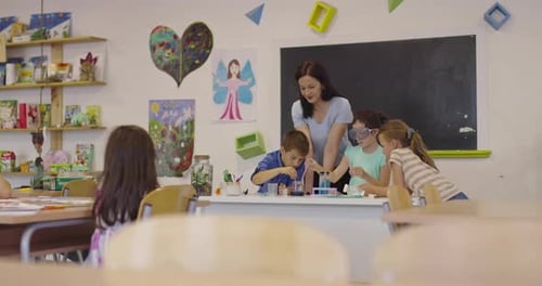 Elementary School Science Classroom Enthusiastic Teacher Explains Chemistry to Diverse Group of