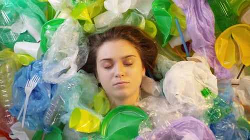Woman Surrounded by Colorful Single-Use Plastic Garbage
