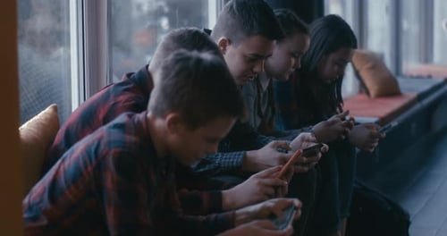 Students Using Smartphone in School Corridor