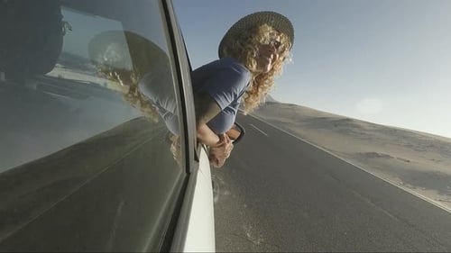 Woman Enjoys Desert Road Trip With Hands Out Window