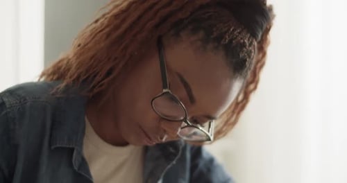 Young Adult Studying and Writing in a Notebook
