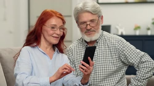 Senior Couple Using Smartphone Technology Together at Home