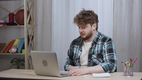 Man Uses Laptop for Online Video Conference