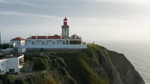 Aerial View of a Lighthouse Surrounded with Rugged Coastline
