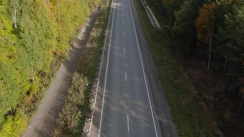 Asphaltstraße mit Autos zwischen Wald im Ural
