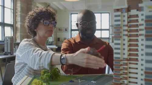 Two Architects Discussing Model of Residential Building