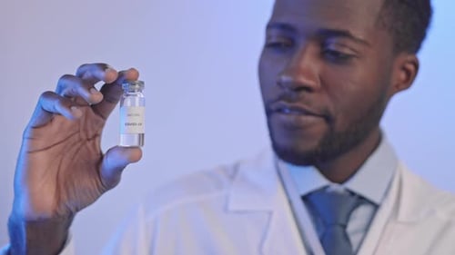 African-American Doctor Holding Bottle with Vaccine from Covid-19