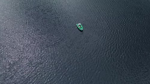 Drone Shooting of a Young Girl and a Man in a Rowboat Surrounded By Water By Ripples on the Surface