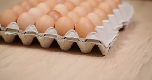 Carton of Brown Eggs on Wooden Table