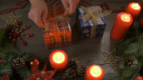 Hands Tying Ribbon on Christmas Present