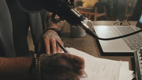 Man Prepares for Podcast Recording at Desk
