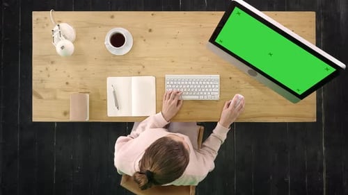 Woman Working At Desk With Green Screen Computer