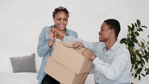 Novio y novia afroamericanos están empacando una caja