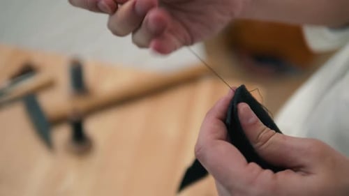 Retro-Lifestyle, Nahaufnahme, Handwerker, der mit Taschen oder Schuhen aus Naturleder arbeitet, kleine Unternehmen