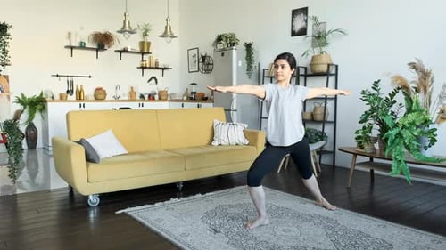 Yoga class at home. Young Indian woman practices yoga at home. Flexible girl doing stretching