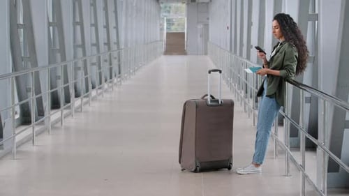 Hispanic Young Girl Woman Traveler Female Passenger Stands with a Suitcase Luggage in Airport