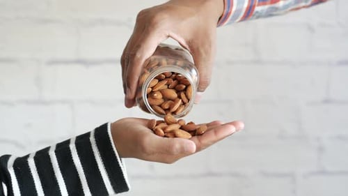 Almonds Being Poured Into Open Hand