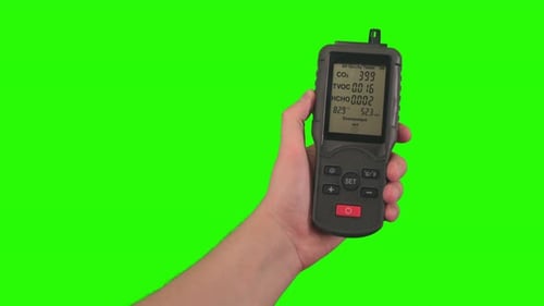 Hand Holding Air Quality Tester on Green Screen
