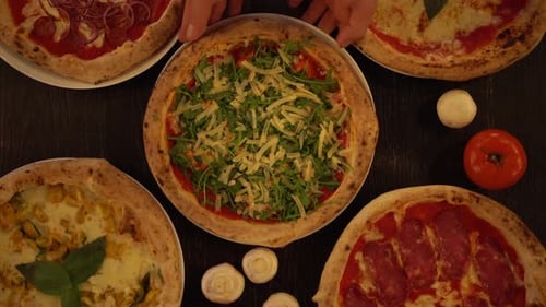Serving Freshly Made Arugula and Cheese Pizza on a Wooden Table