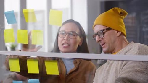 Asian Woman and Middle-Aged Man Brainstorming Ideas in Office