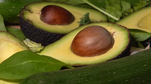 Fresh Sliced Avocados and Green Vegetables Close Up