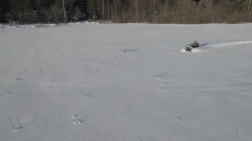 Snowmobile Ride Across a Snowy Rural Field