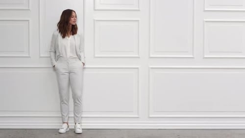 Attractive Woman Posing in White Pantsuit Indoors