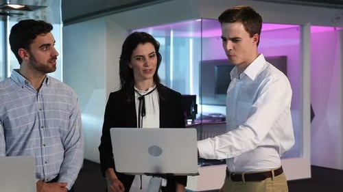 Smiling Colleagues Discussing Project at Modern Office