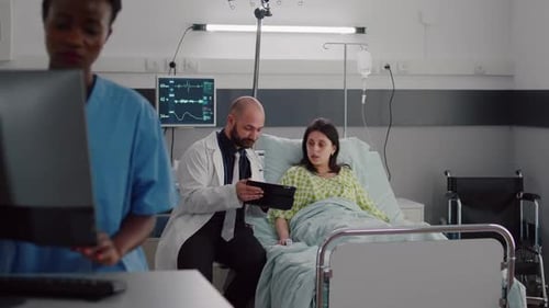 Doctor Consults with Patient in Hospital Room