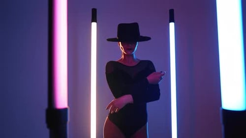 Stylische Tänzerin mit Hut, Body und Strümpfen, tanzt mit den Händen,