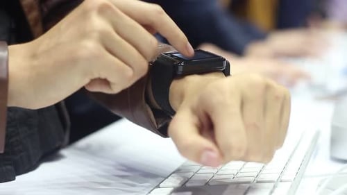 Frau benutzt eine Smartwatch im Büro