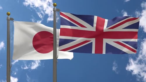 Japan and United Kingdom Flags Waving in Blue Sky