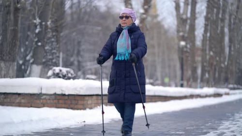 Senior Woman Using Walking Poles in Winter Park