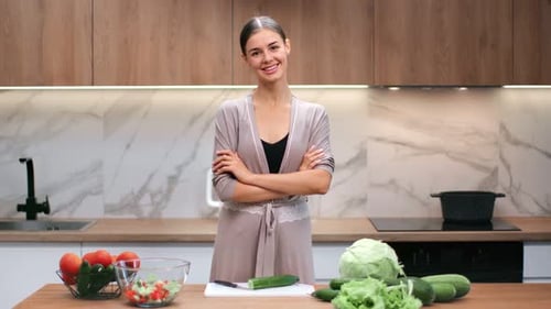 Smiling Woman with Vegetables in Bright Kitchen