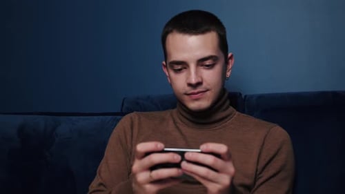 Close Up Caucasian Man Playing Game on Phone and Looking Concentrated and Happy. Handsome Man