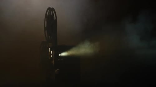 Vintage Film Projector Emitting Light in Dark Room