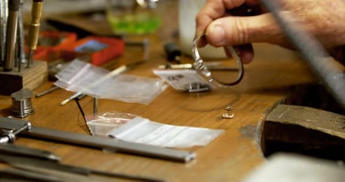 Goldsmith working at desk in workshop 4k