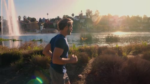 Athletic Man Jogging Around A Small Lake