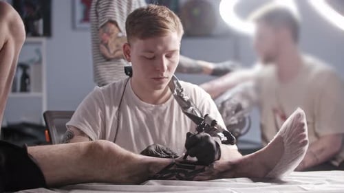 Tattoo Artist Gives Leg Tattoo in Bright Studio